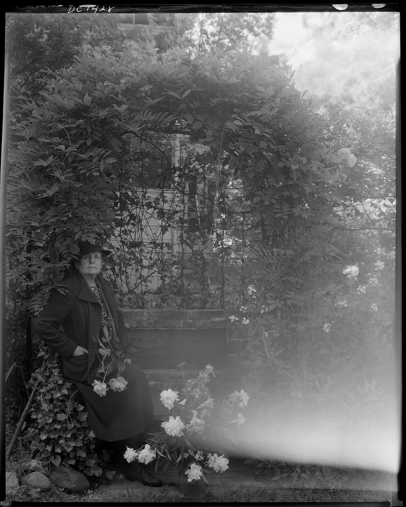[Frances Benjamin Johnston, photographer, posed sitting with peonies…, 1938