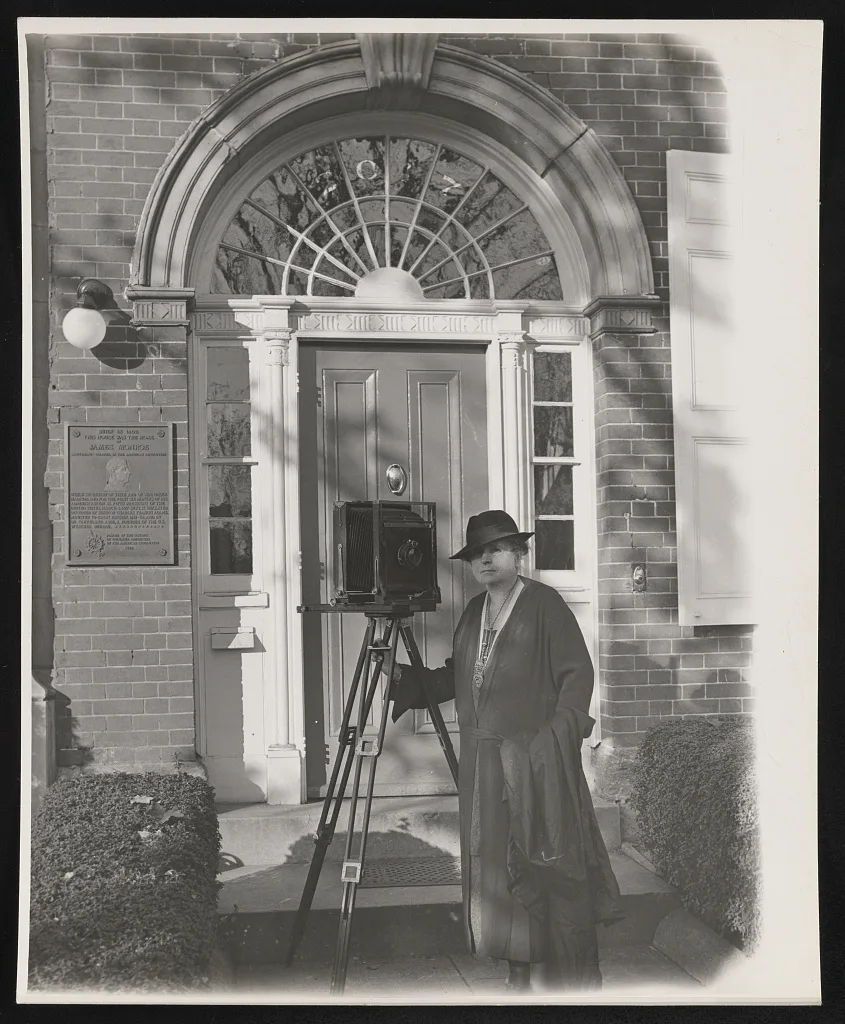 [Frances Benjamin Johnston with large tripod camera, in front of the…, 1936